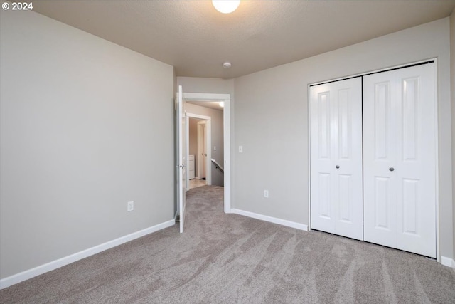 unfurnished bedroom with light carpet and a closet