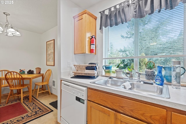 kitchen with sink, hanging light fixtures, light brown cabinets, white dishwasher, and a notable chandelier