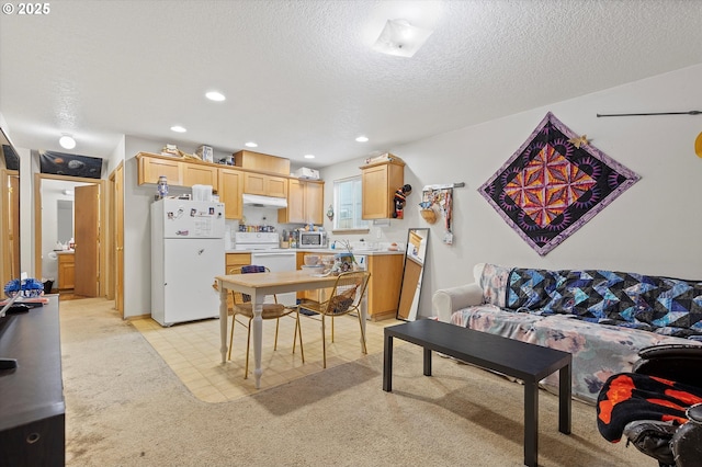 dining space with light carpet and a textured ceiling