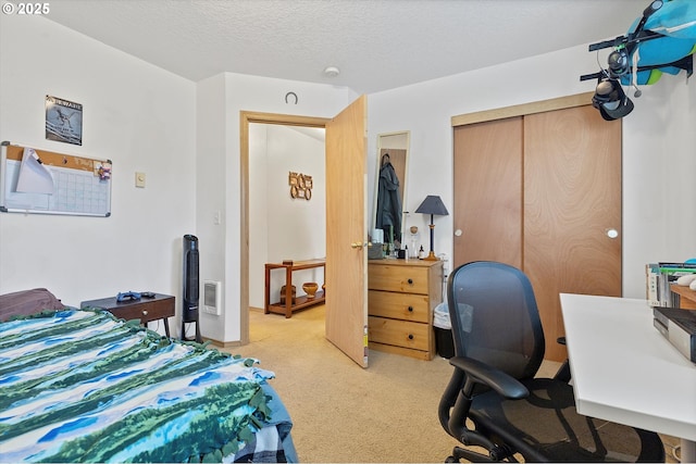 carpeted bedroom featuring a closet and a textured ceiling