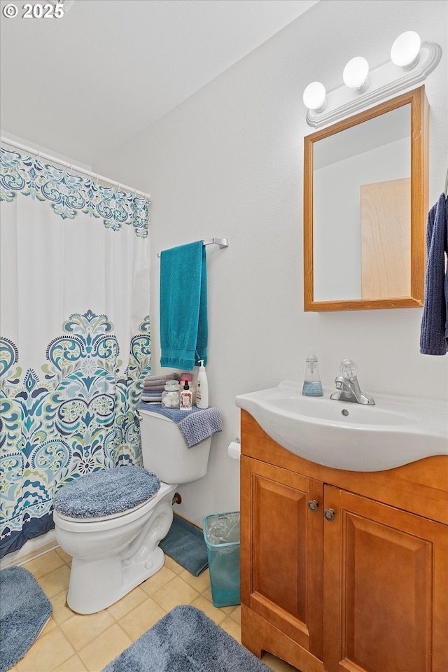 bathroom with tile patterned flooring, vanity, and toilet