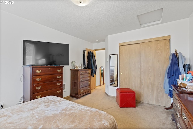 carpeted bedroom with a textured ceiling and a closet