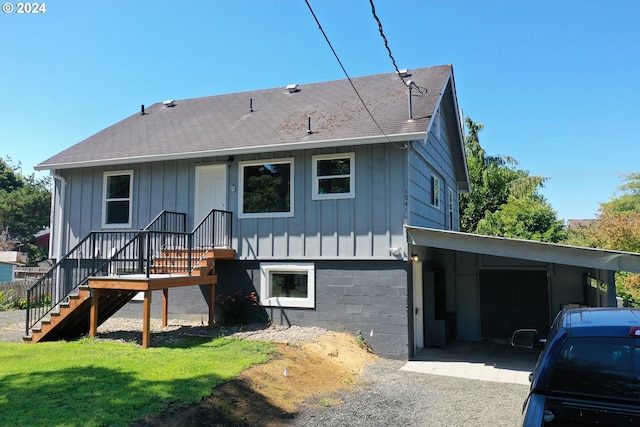 rear view of property with a yard, board and batten siding, and roof with shingles