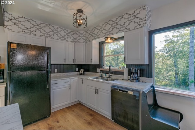 kitchen with a healthy amount of sunlight, black appliances, light countertops, and a sink