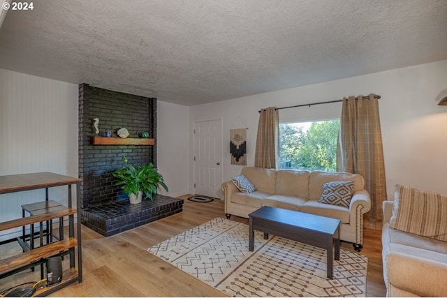 living area featuring a fireplace, wood finished floors, and a textured ceiling