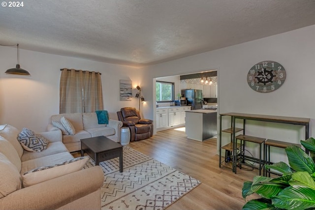 living room featuring light wood-style flooring and a textured ceiling