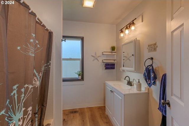 full bath featuring visible vents, baseboards, a shower with curtain, wood finished floors, and vanity