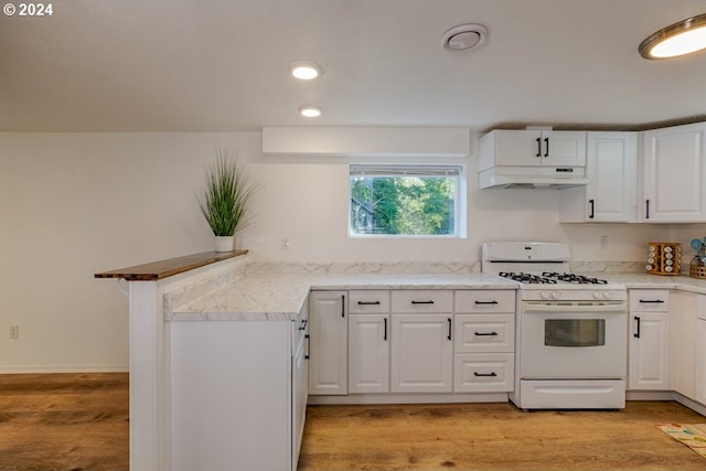 kitchen with white gas stove, white cabinets, light wood-type flooring, and under cabinet range hood