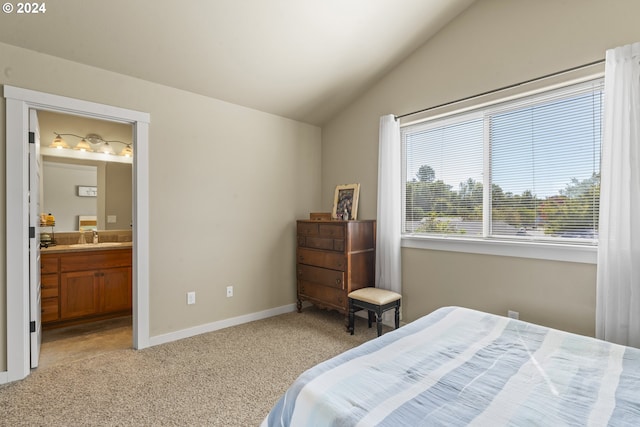 bedroom featuring light carpet, ensuite bath, vaulted ceiling, and sink