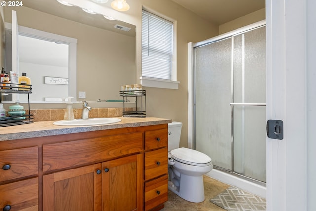 bathroom featuring vanity, toilet, and a shower with shower door