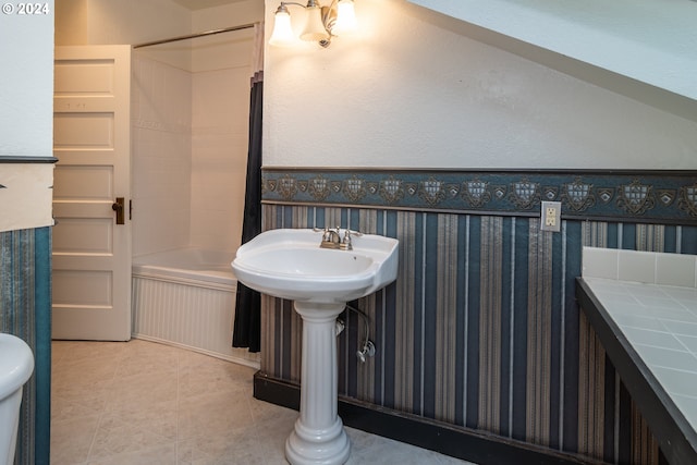 bathroom featuring wallpapered walls, shower / washtub combination, and tile patterned floors