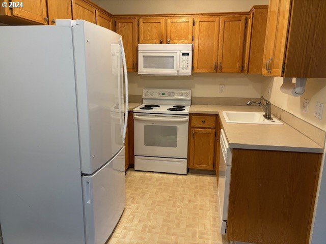 kitchen featuring white appliances and sink