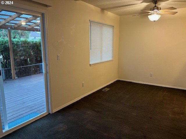 carpeted empty room featuring ceiling fan