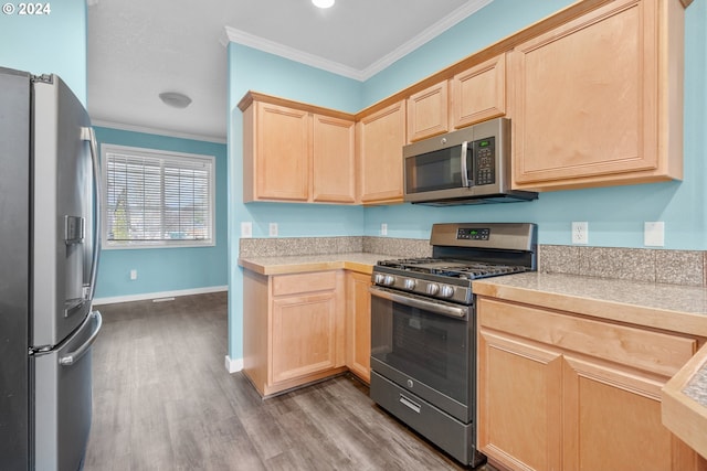 kitchen featuring ornamental molding, light brown cabinetry, wood-type flooring, and appliances with stainless steel finishes