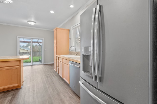 kitchen featuring ornamental molding, stainless steel appliances, sink, tile countertops, and light hardwood / wood-style flooring