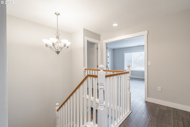 hallway featuring dark hardwood / wood-style flooring and a chandelier