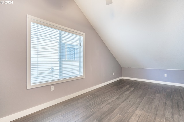 additional living space featuring ceiling fan, dark wood-type flooring, and vaulted ceiling