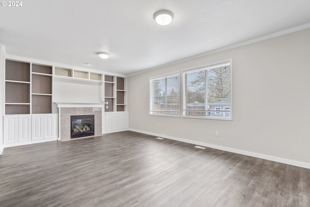 unfurnished living room with wood-type flooring, a textured ceiling, and crown molding