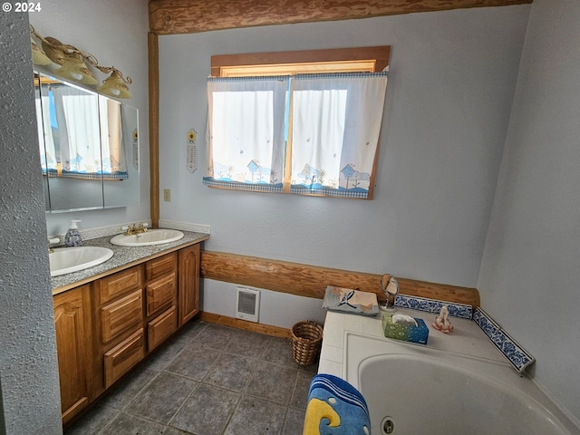 bathroom featuring baseboards, a whirlpool tub, a sink, and visible vents