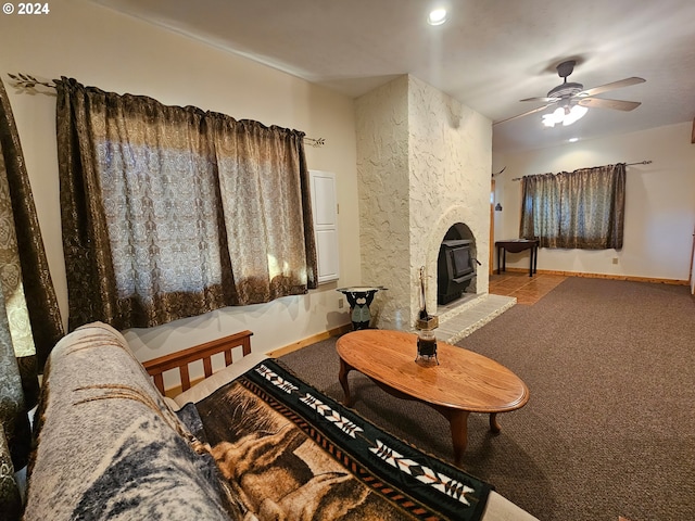 living room featuring a wood stove, carpet, and ceiling fan