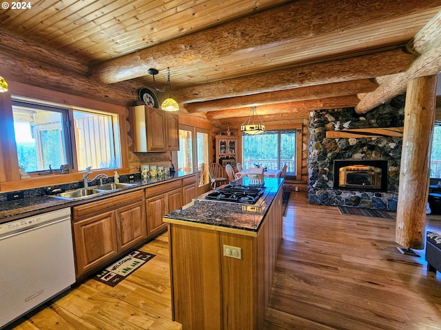 kitchen with white dishwasher, beamed ceiling, a kitchen island, and light hardwood / wood-style flooring