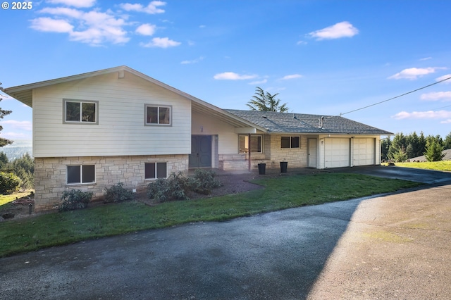 tri-level home featuring a front yard and a garage