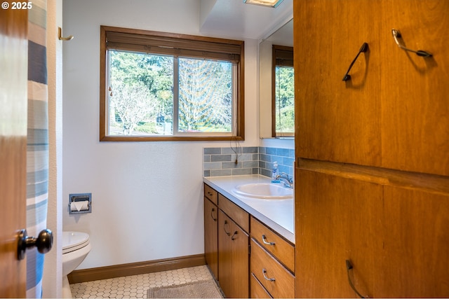 bathroom featuring vanity, backsplash, and toilet