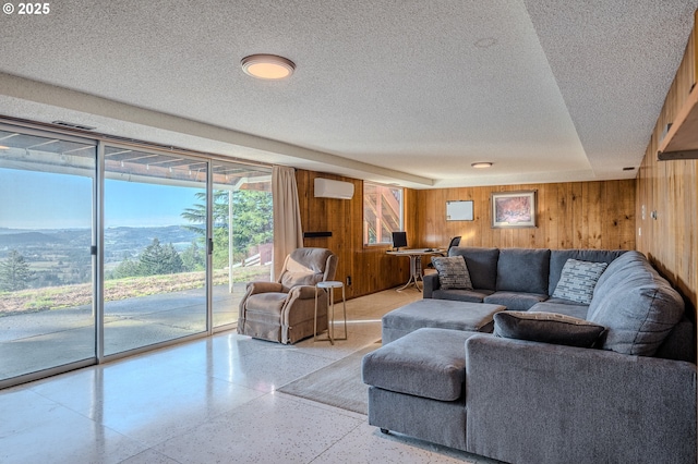 living room with wooden walls, a mountain view, and a wall mounted air conditioner