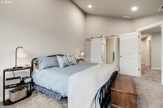 bedroom featuring high vaulted ceiling, a barn door, recessed lighting, visible vents, and carpet