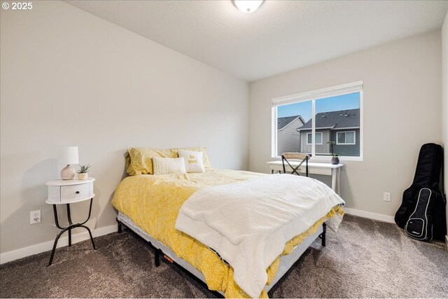 bedroom featuring dark carpet and baseboards