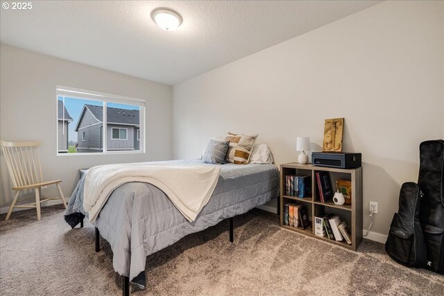 carpeted bedroom with baseboards and a textured ceiling