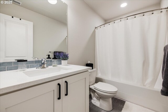 full bathroom featuring visible vents, toilet, wood finished floors, shower / tub combo with curtain, and vanity