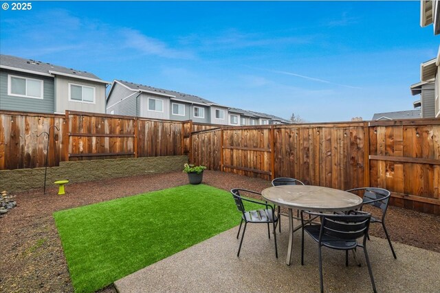 view of patio featuring a fenced backyard, a residential view, and outdoor dining area