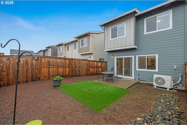 rear view of house with a patio, ac unit, board and batten siding, and a fenced backyard