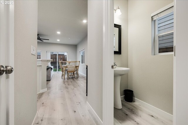 bathroom with baseboards, wood finished floors, and recessed lighting