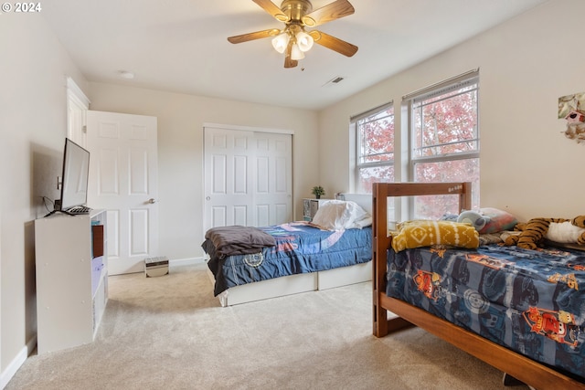 bedroom featuring light carpet, a closet, and ceiling fan