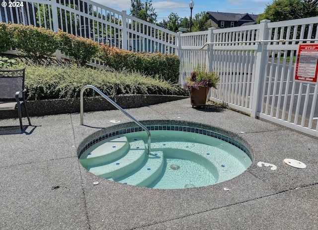 view of pool with a hot tub, a patio, and fence