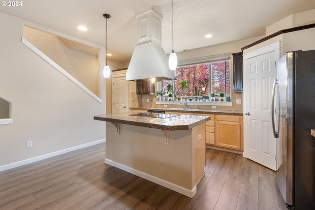 kitchen featuring decorative backsplash, dark hardwood / wood-style floors, black appliances, and a kitchen island