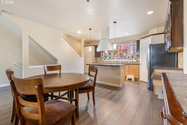 dining room with sink, dark wood-type flooring, and a textured ceiling