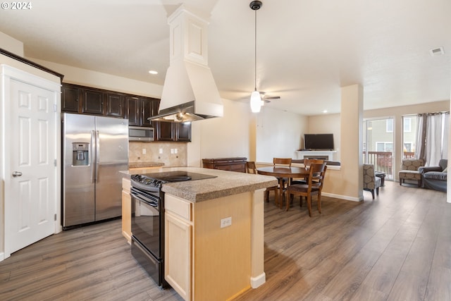 kitchen with dark brown cabinets, stainless steel appliances, wood-type flooring, and decorative backsplash