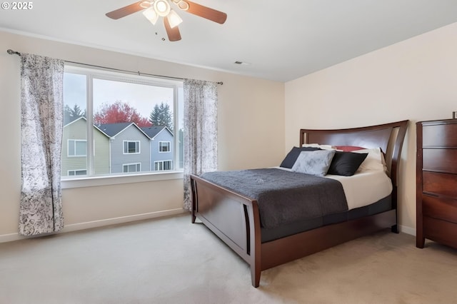 carpeted bedroom with visible vents, baseboards, and ceiling fan