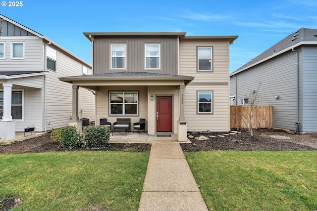 view of front facade featuring board and batten siding, a front yard, fence, and central AC unit