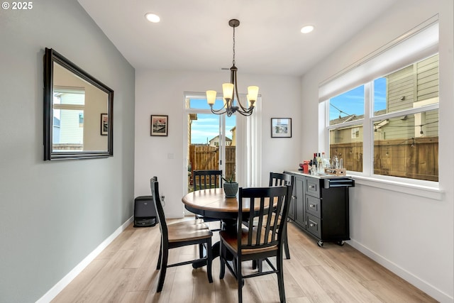 dining space featuring light wood-style floors, recessed lighting, baseboards, and an inviting chandelier