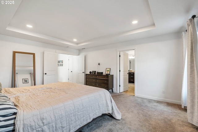 bedroom with a tray ceiling, carpet, recessed lighting, and baseboards