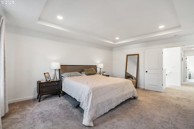 bedroom featuring a tray ceiling, light colored carpet, and baseboards