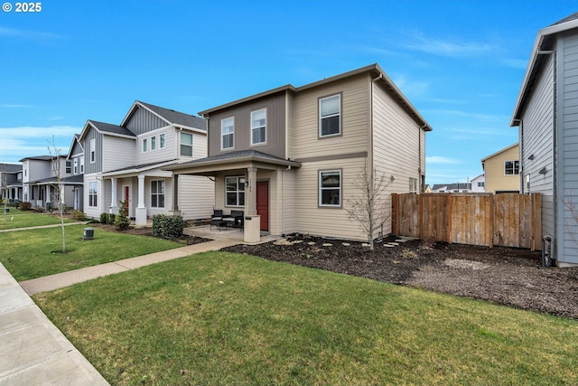 view of front facade with a residential view, fence, a patio, and a front yard