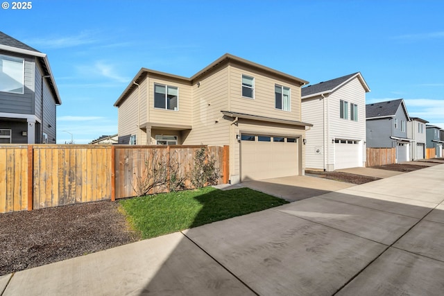 view of front of home with an attached garage, fence, and concrete driveway