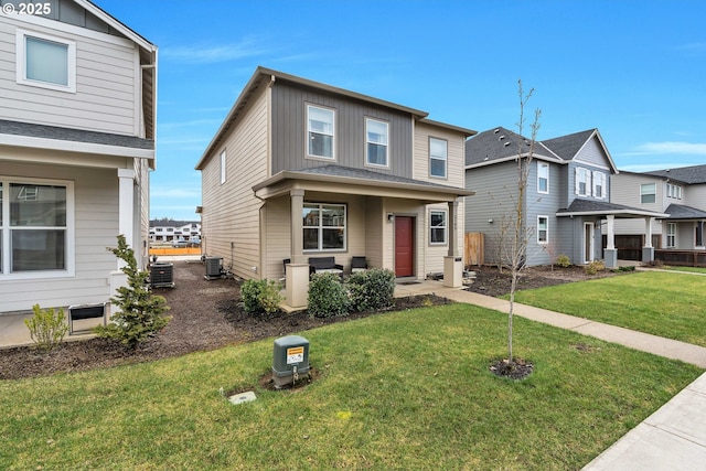 view of front facade featuring central AC unit, board and batten siding, and a front yard