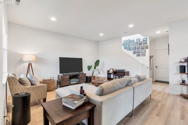 living room with light wood-style flooring, stairs, visible vents, and recessed lighting