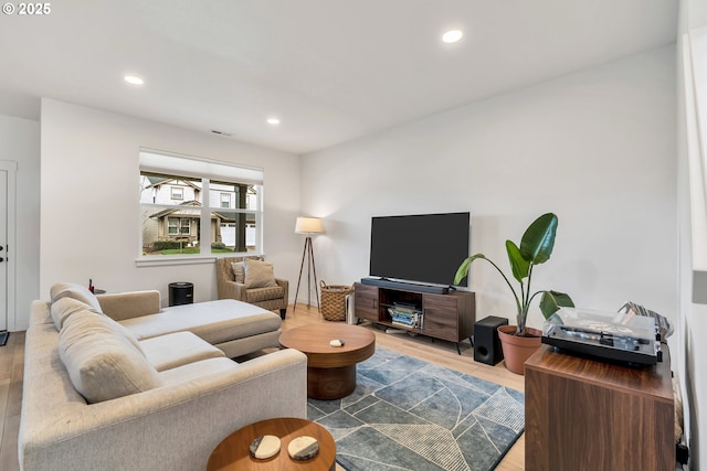 living area with recessed lighting, visible vents, and wood finished floors